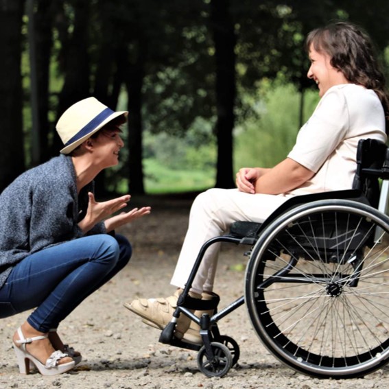 Woman speaking to another woman in a wheelchair